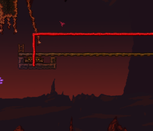 A teleporter with a Pressure Plate track above, at the end of a long rail. Red wire leads away from the image.
